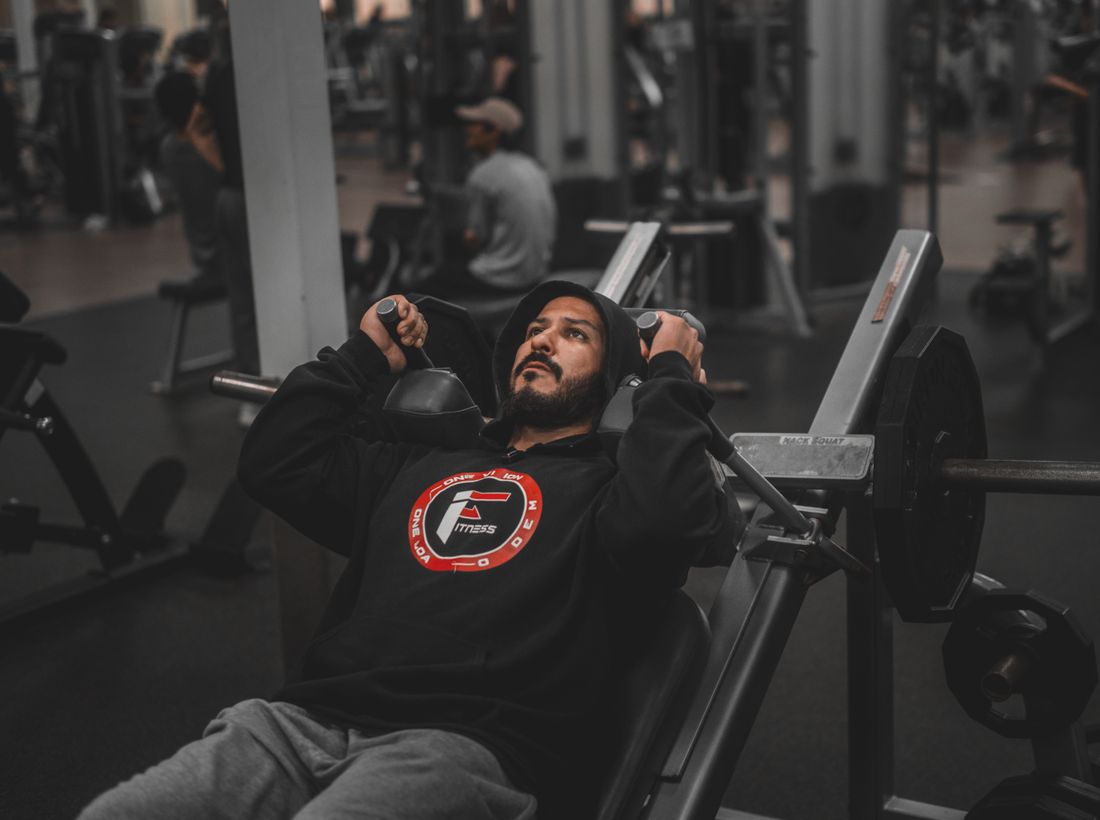 Man lifting weights on a bench press in a modern gym