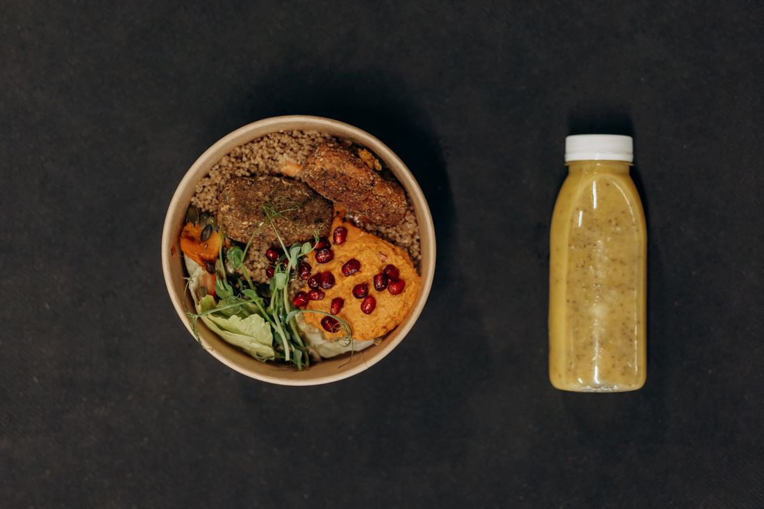 Vegan bowl with quinoa, vegetables, and a smoothie bottle